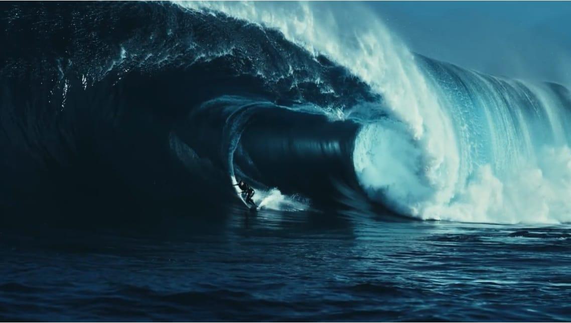 A surfer riding the barrel of a large ocean wave